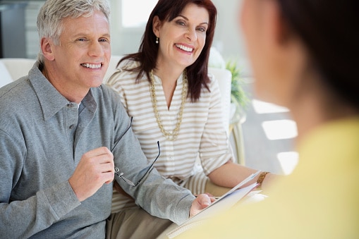 Female Medicare insurance agent and advisor working with couple.